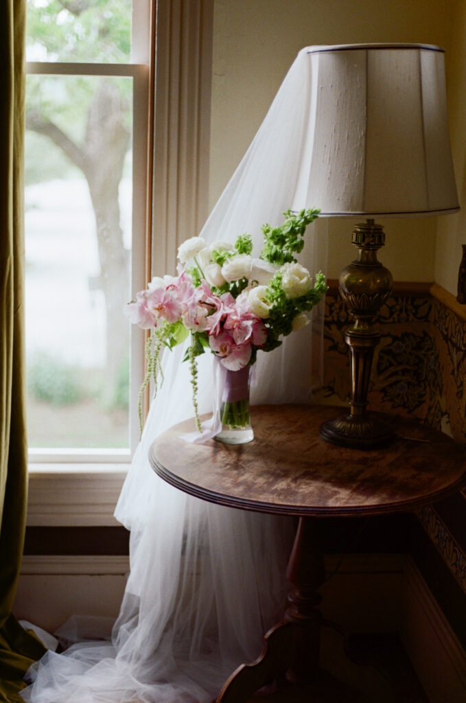 Bridal bouquet and veil displayed beside a window before an Austin wedding