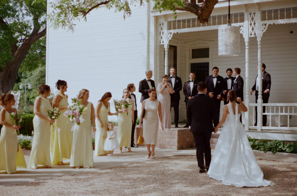 Bride and groom walking toward their wedding party outside an Austin wedding venue