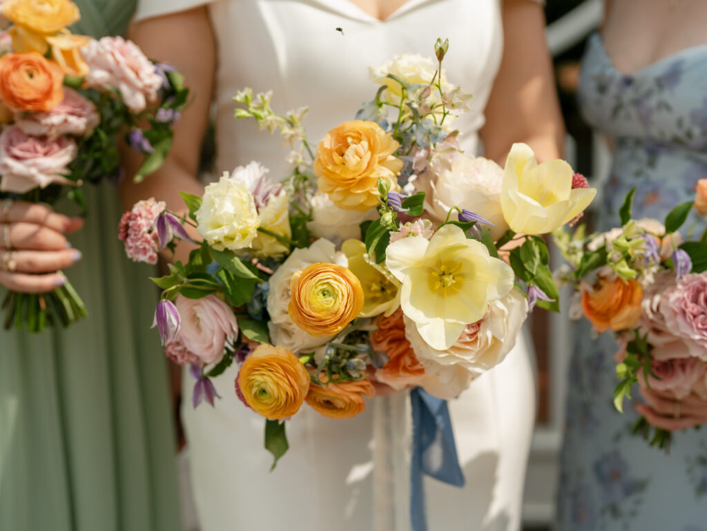 Close-up of colorful bridal and bridesmaid bouquets at a Woodbine Mansion wedding.