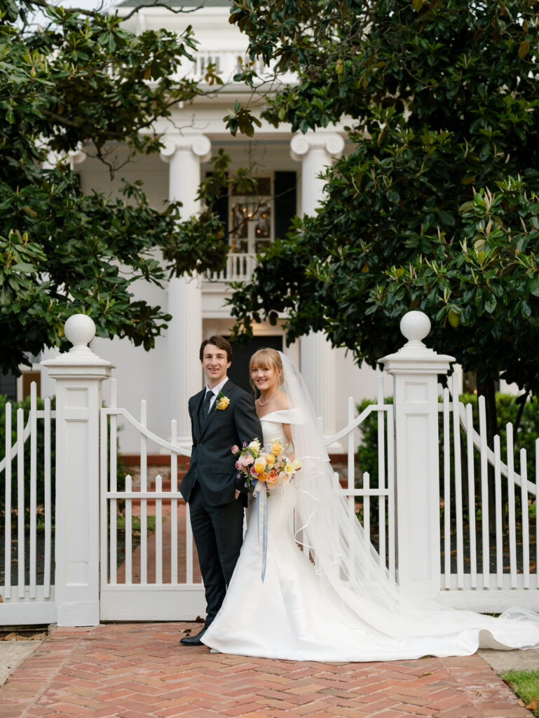 Newlyweds posing outside the garden gate at Woodbine Mansion in Round Rock, Texas.