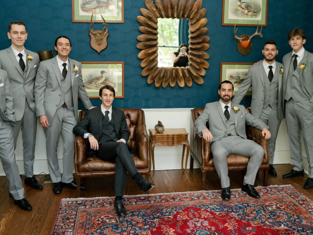 Groom and groomsmen posing in a historic sitting room inside Woodbine Mansion before the wedding ceremony.