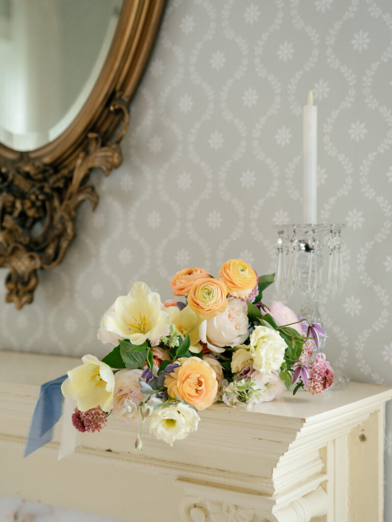 Colorful bridal bouquet displayed on a historic mantel inside Woodbine Mansion.