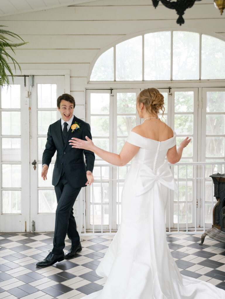 Bride and groom sharing a joyful first look inside Woodbine Mansion before their wedding ceremony.